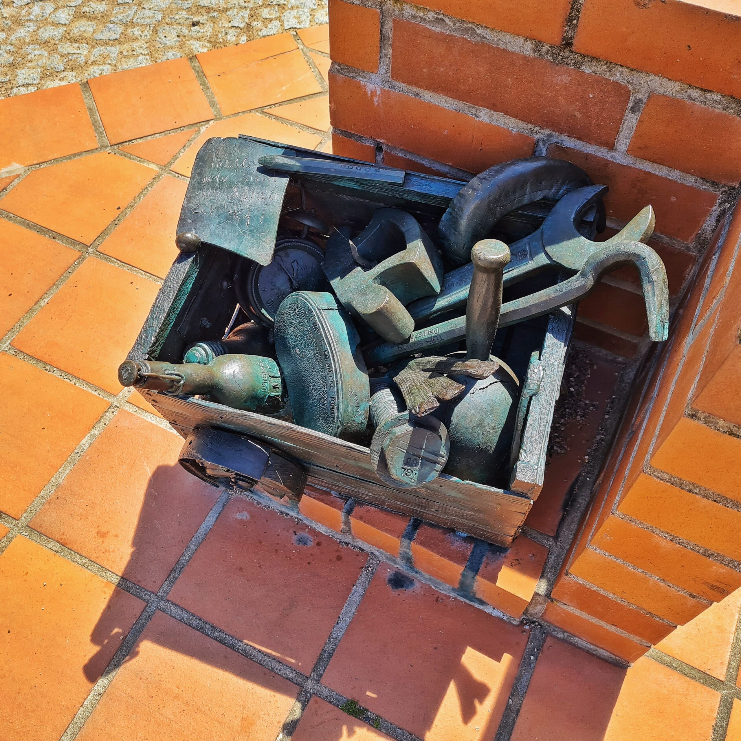 Ein nach oben offener Kasten aus Metall, aus dem verschiedene Werkzeuge ragen.