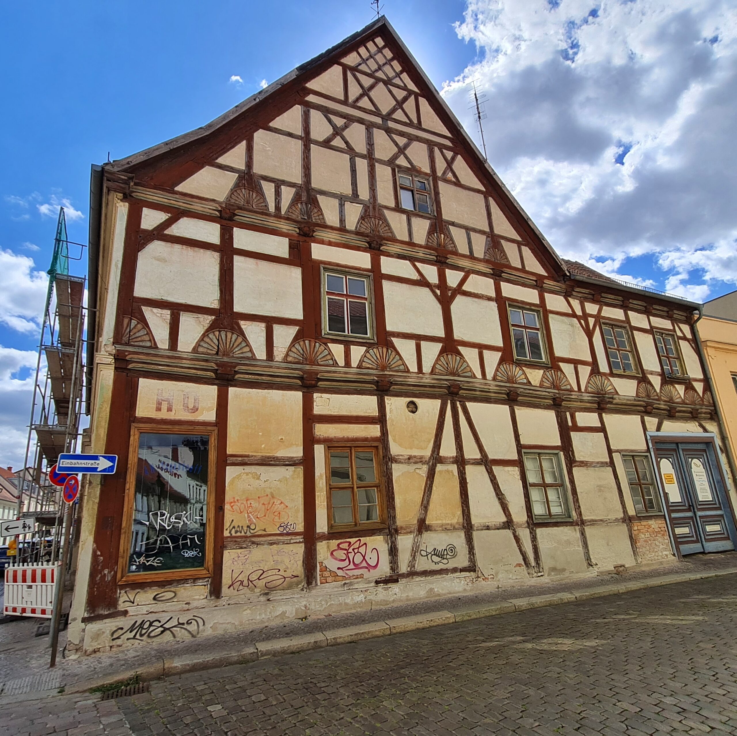 Ein helles Haus mit braunem Fachwerk.