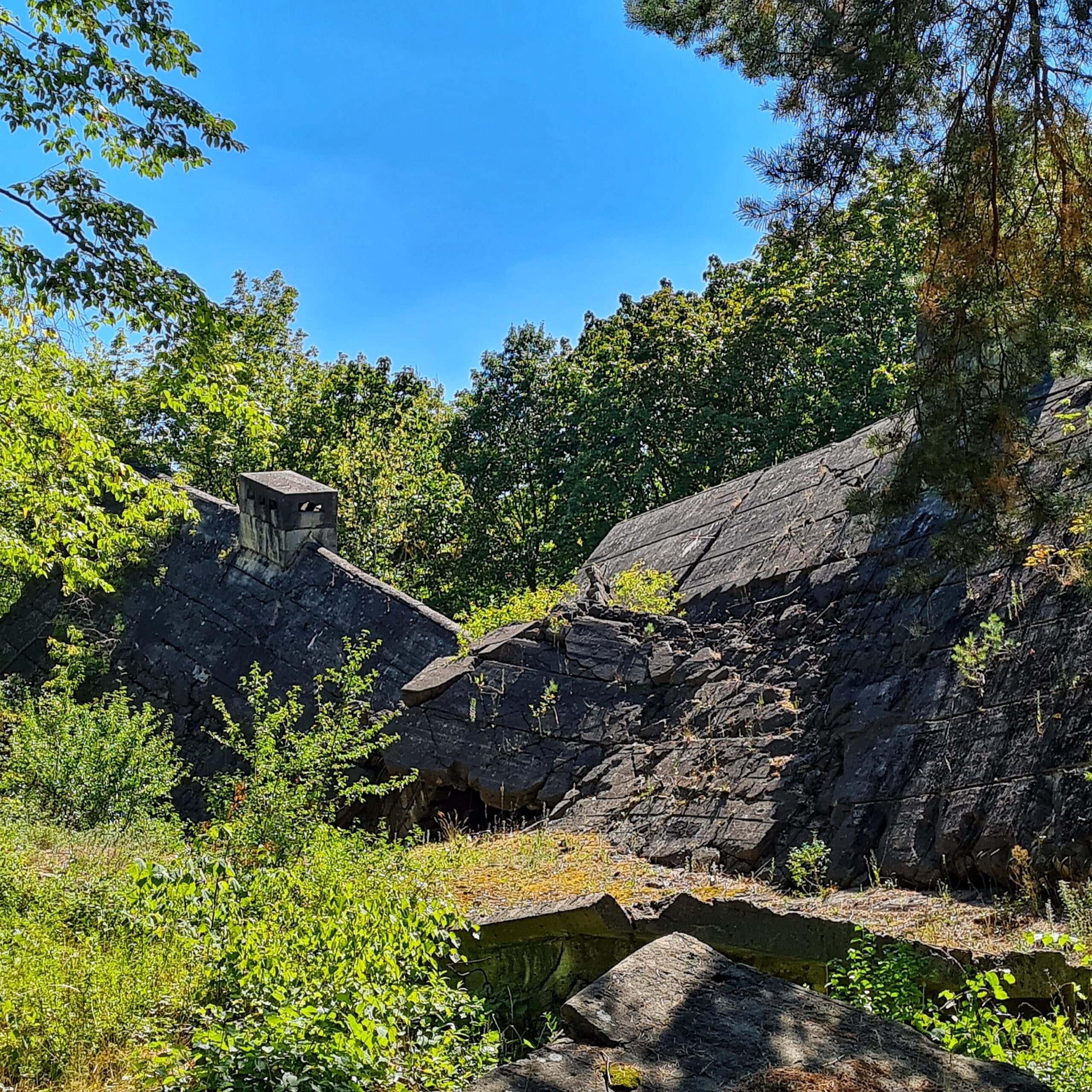 Ein zusammengestürztes Gebäude. Hinten ist noch ein Teil des Daches mit eines Schornstein erkennbar.