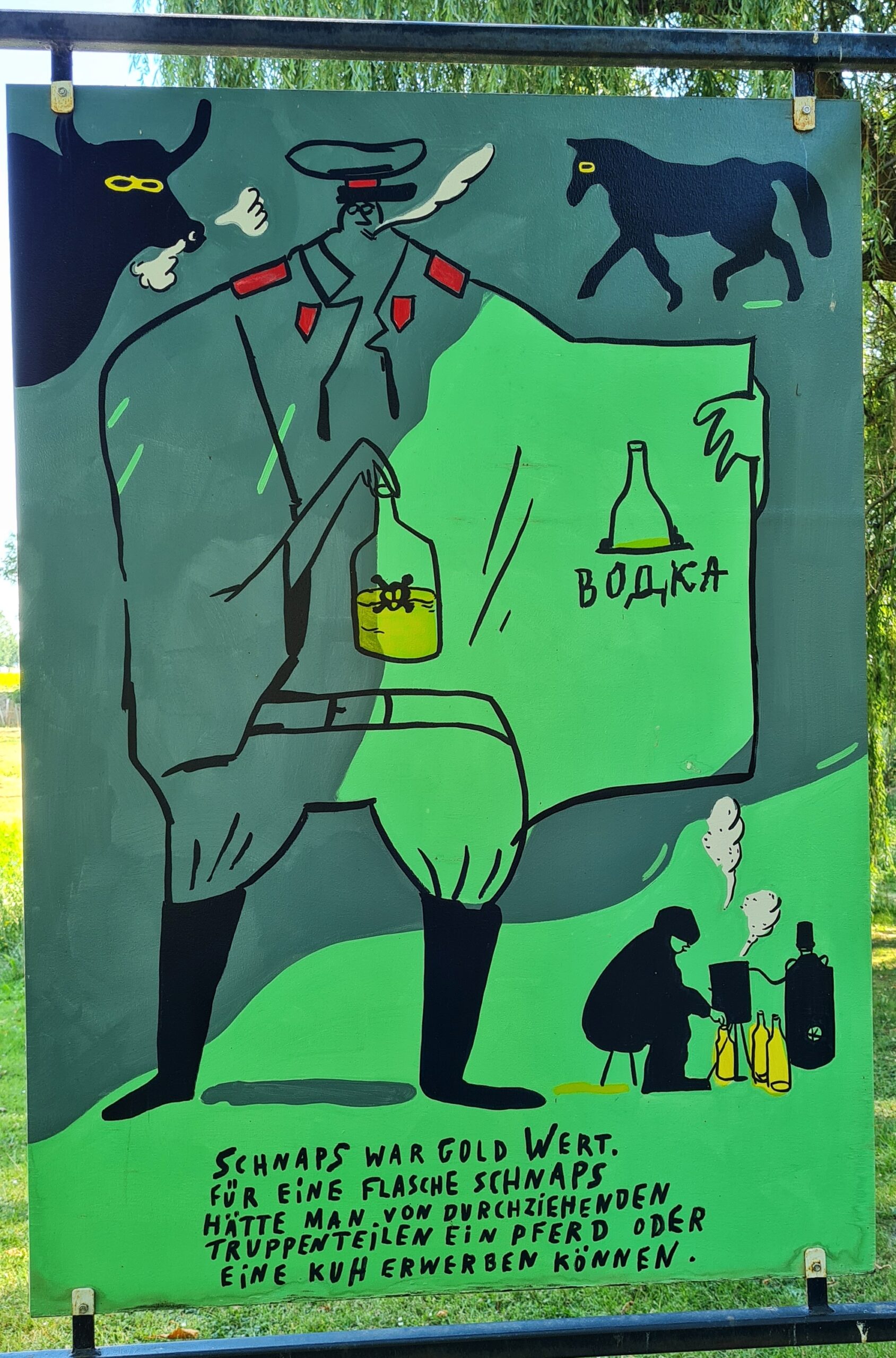 Die Zeichnung eines großen Mannes in Uniform von vorne. Die eine Seite seiner Jacke hat er geöffnet. In der Innentasche steckt eine Flasche. Darunter steht etwas auf russisch, vermutlich: Wodka. In der anderen Hand hält er auch eine Flasche. Links oben von ihm die Zeichnung eines schnaubenden Stieres, rechts oben di eines Pferdes. Unten rechts sitzt ein Mann vor einem Topf, aus dem es dampft. Daneben ein Gasbehälter und mehrere Flaschen. Ganz unten der Text: Schnaps war Gold wert. Für eine Flasche Schnaps hätte man von durchziehenden Truppenteilen ein Pferd oder eine Kuh erwerben können.