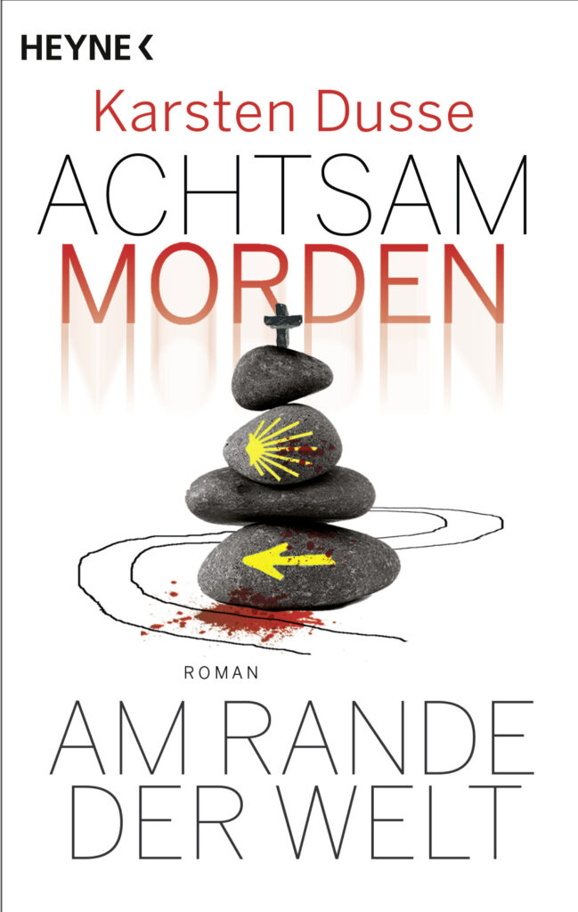 Buchcover. Oben: Heyne. Karsten Dusse. Achtsam morden. Darunter mehrere graue, flache Steine übereinander gestapelt. Auf den untereen ist ein gelber Pfeil nach links gemalt. auf einen der mittleren ist eine gelbe Jakobsmuschel gemalt. Auf dem oberste ein kleines Kreuz. Darunter steht: Am Rande der Welt.