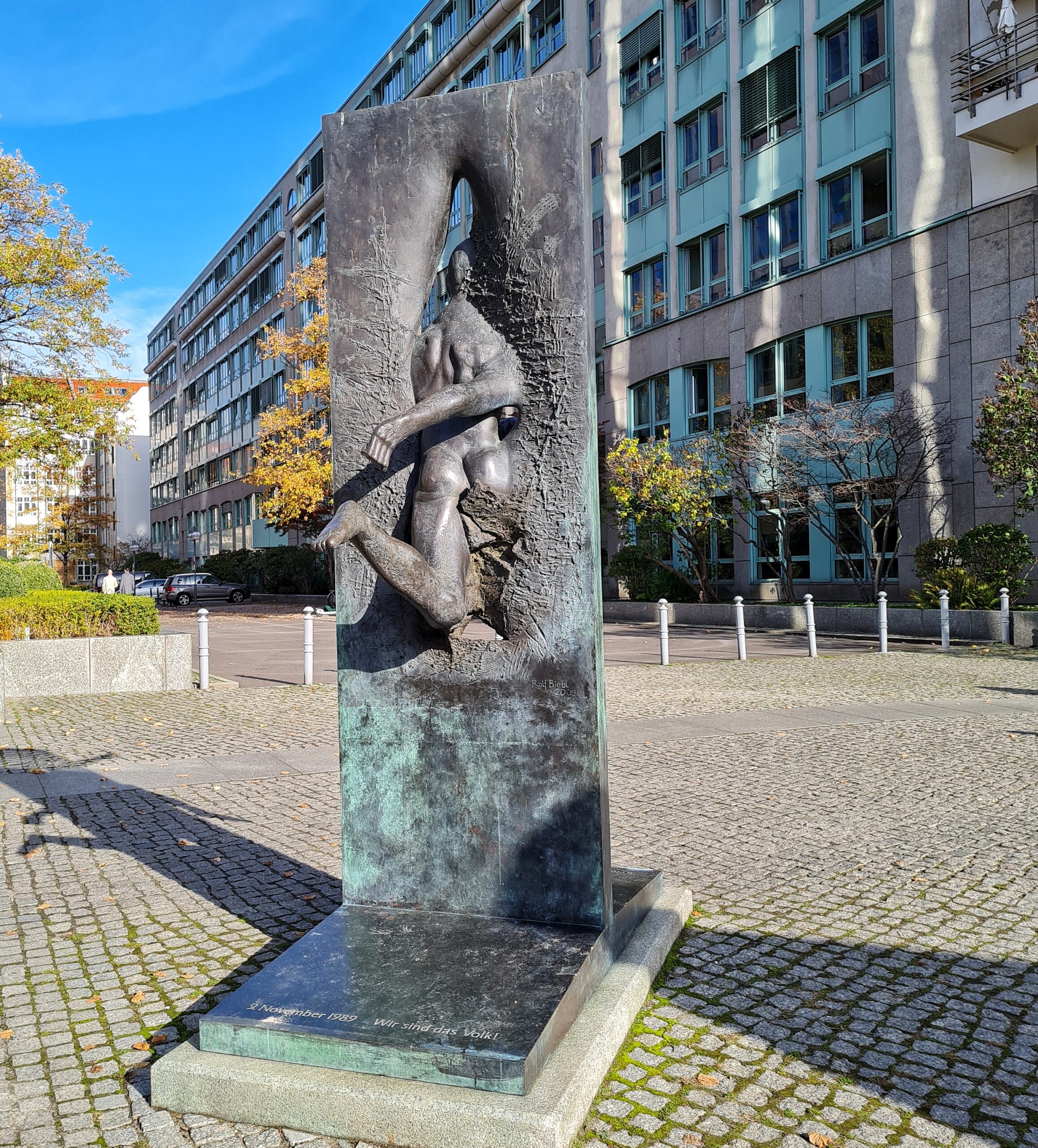 Der hintere Teil der Metallplatte mit Rücken, Po, nach hinten ausgestrecktem Bein und nach hinten angewinkelten Bein des Mannes.